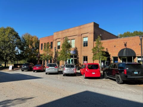 Parking lot and landscaped common area at a multi-tenant commercial building in Watkinsville, Georgia.